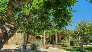 A courtyard with a stone building, a gravel path, and greenery. - Vivamont, Villa-Finca 5StarsHome Mallorca (Pollensa / Pollença)