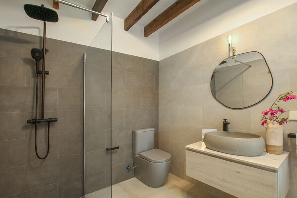 A modern bathroom with a glass-enclosed shower, a toilet, and a sink with a round basin. - Vivamont, Villa-Finca 5StarsHome Mallorca (Pollensa / Pollença)