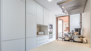 A modern kitchen with white cabinetry, a built-in oven, and stainless steel cookware. - Pollensi, Adosado 5StarsHome Mallorca (Pollensa / Pollença)