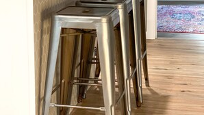 A kitchen with a central island, stainless steel stools, and a decorative plant. - Curated for Fun with Hot Tub, Bikes, Fire Pit & More! (Kerrville)