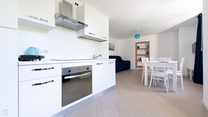 A modern kitchen with white cabinetry, a built-in oven, and a blue kettle. - Villa Tola - Blu - One Bedroom Apartment, Sleeps 5 (Valdisotto)
