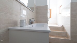 A modern bathroom with a large sink, a mirror, and a shower area. - Villa Tola - Blu - One Bedroom Apartment, Sleeps 5 (Valdisotto)