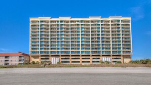 Ein mehrstöckiges Hotel mit einheitlicher Fassade, zahlreichen Balkonen und einer flachen Dachfläche.