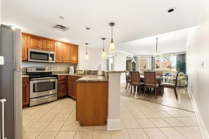 A modern kitchen with granite countertops, stainless steel appliances, wooden cabinets, and pendant lighting. - Mar Vista Grande 515-3BR/3BA Oceanfront condo in Ocean Dr. (North Myrtle Beach)