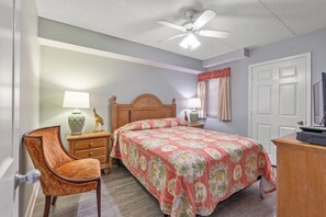Classic bedroom with a wooden bed, matching headboard, and floral-patterned bedspread.