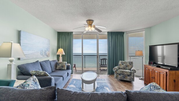 A living room with a sofa, armchair, and a television. - North Shore Villas 903-3BR/3BA Oceanfront-Ocean Drive (North Myrtle Beach)