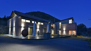 Una casa moderna con un patio amplio, ventanas grandes y una entrada bien iluminada.