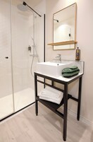 A bathroom with a shower, sink, and mirror.