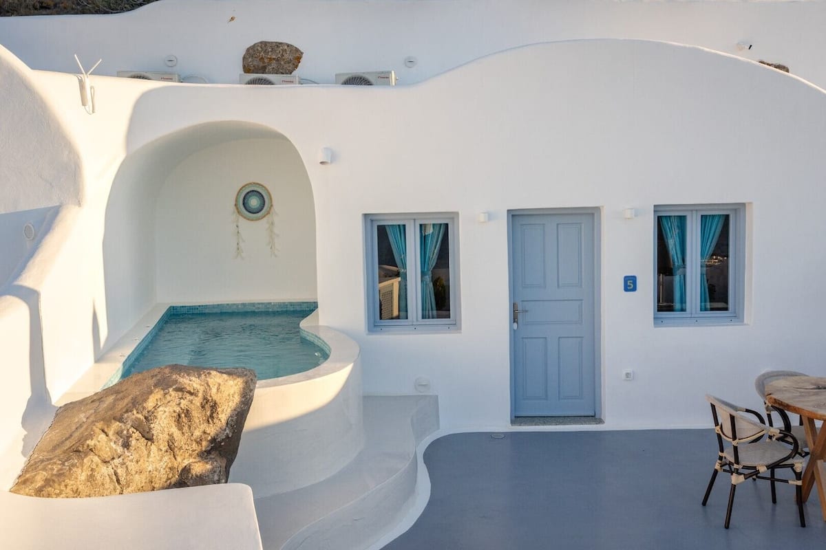 A white-walled building with a pool, a door, and a window.