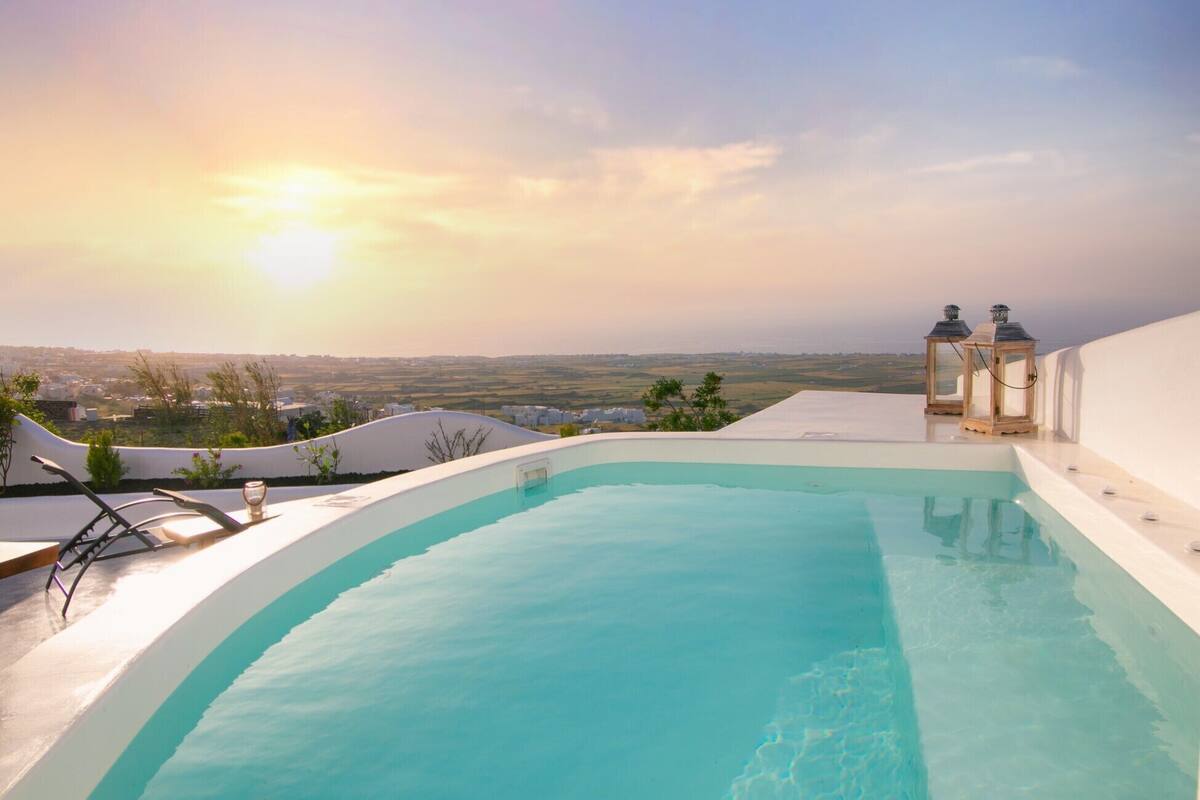 A rooftop infinity pool with a view of the landscape and distant city.