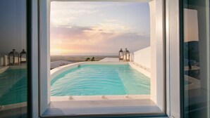 Une piscine offrant une vue dégagée sur le coucher de soleil et le paysage.