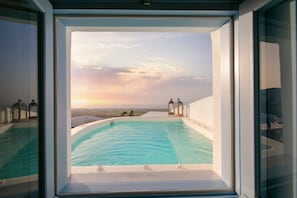 Una piscina con vistas despejadas al atardecer y al paisaje.