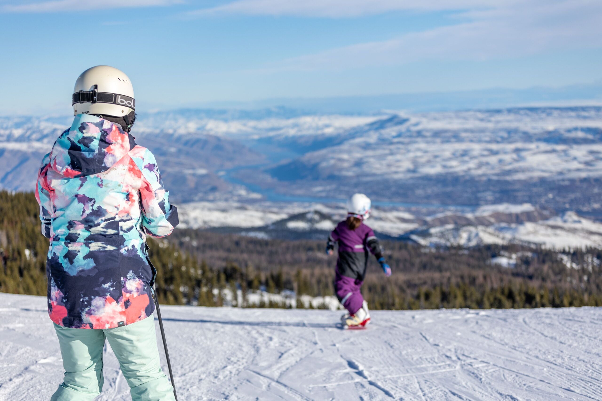 Un paysage enneigé avec une personne qui fait du ski au loin.