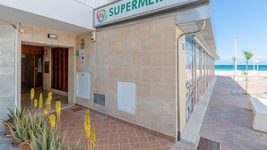 A building with a sign reading "SUPERMERCAT" and a tiled entrance. - YourHouse Blaublue 2.3, wonderful sea view apartment in Majorca North (Can Picafort)
