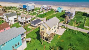 Uma área residencial costeira com casas, uma praia e um céu claro.