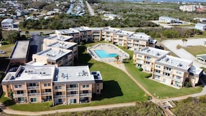 A multi-story hotel with a central courtyard, outdoor pool, and multiple balconies. - Creston House 11C~Watch the Waves Roll in at this Oceanfront Beauty! (St. Augustine)