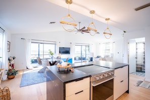 Enjoy a spacious living area with a central kitchen island and stove, perfect for cooking and socializing.