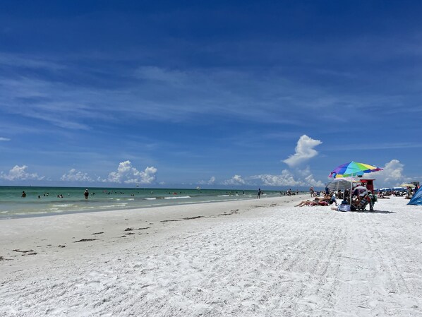 Guests can enjoy swimming and sunbathing on the beach with umbrellas providing shade.