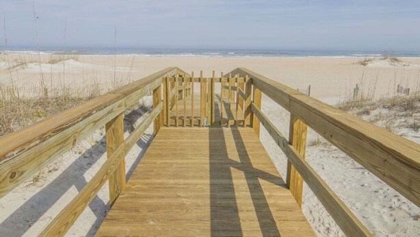 A wooden boardwalk leading to a sandy beach with a clear sky. - Island South 33 Ocean View Condo On Third Floor (St. Augustine)