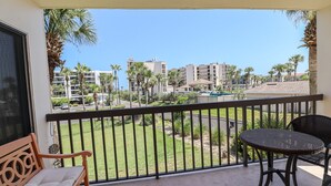 Un balcón con vistas a una zona residencial, con palmeras y edificios.