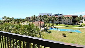 Un hôtel doté d’une piscine, de palmiers et offrant une vue dégagée sur l’océan.