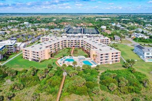 A large, multi-story hotel with a central courtyard and swimming pool.