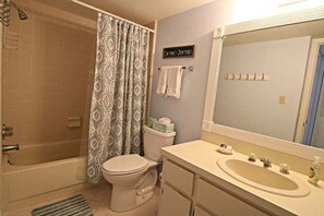 A bathroom with a bathtub, toilet, and sink. - Sand Dollar 2-302 Private Balcony, Direct Oceanfront, Beach Views (St. Augustine)