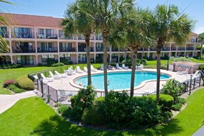 A hotel with a swimming pool surrounded by palm trees and lounge chairs. - Updated, Classy Ground Floor Condo-Sea Place 12119 (St. Augustine)