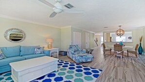 A spacious living room with a blue sofa, a white coffee table, and a patterned rug. - Luxury at the Beach, Totally Remodeled with Ocean Views Sea Place 12214! (St. Augustine)