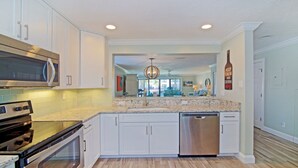 A modern kitchen with white cabinets, stainless steel appliances, and a granite countertop. - Luxury at the Beach, Totally Remodeled with Ocean Views Sea Place 12214! (St. Augustine)