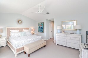 A bedroom with a bed, a nightstand, a dresser, a mirror, and a ceiling fan. - Luxury at the Beach, Totally Remodeled with Ocean Views Sea Place 12214! (St. Augustine)