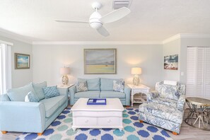 A living room with a ceiling fan, two sofas, a coffee table, and a patterned rug. - Luxury at the Beach, Totally Remodeled with Ocean Views Sea Place 12214! (St. Augustine)