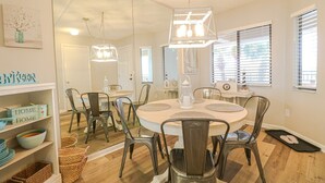 Un espace repas comprenant une table ronde, des chaises et un luminaire suspendu.