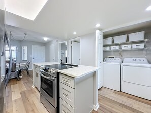 A compact kitchen with a built-in oven, a stovetop, and a countertop. - Windjammer 109 - Comfortable Ocean View Condo, 2BR, Great Rates, Elevator & Covered Parking (St. Augustine)