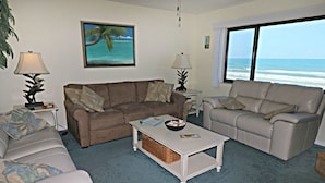 A living room with two sofas, a coffee table, and a view of the ocean. - Windjammer 312 - Remodeled, Direct Oceanfront Three Bedroom Crescent Beach Condo (St. Augustine)