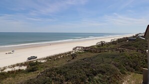 A beach with a wooden boardwalk leading to a beach house. - Windjammer 404 - Updated, 4th Floor Oceanfront Condo with Elevator Access (St. Augustine)