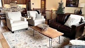 A spacious living room with a fireplace, a dining area with wooden furniture, and a kitchen with modern appliances. - Luxury Mountain Home in Grand Lake - Hot Tub (Grand Lake)
