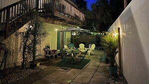 A patio area with outdoor furniture, a covered seating area, and string lights.