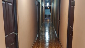 Un pasillo con baldosas estampadas, puertas de madera e iluminación empotrada en el techo.