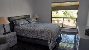 A bedroom with a bed, nightstands, a lamp, a window with a view of the outdoors, and a tiled floor. - 2 Blocks from Carefree, AZ Town Center, Quiet and With Pool! (Carefree)