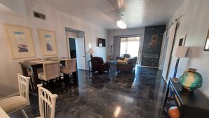 A spacious living area with a dining table and chairs, a sofa, and a decorative vase. - Desert Escape With Pool! (Carefree)