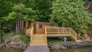 A cabin with a wooden deck and stairs leading to a small entrance. - Bluff`s Charm 3 bedroom lake home on Keuka Lake (Penn Yan)