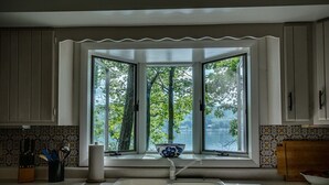 A kitchen with a large window, a sink, and a bowl on the windowsill. - Bluff`s Charm 3 bedroom lake home on Keuka Lake (Penn Yan)