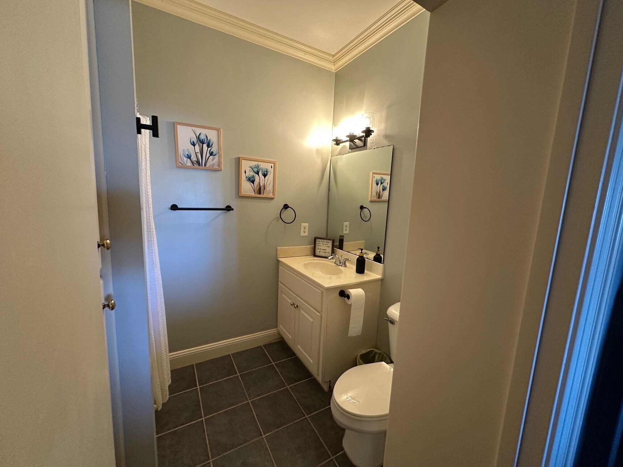 Une salle de bain comprenant des toilettes, un lavabo et un espace douche.