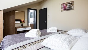 A hotel room with a bed, a desk, a mirror, and a door. - Vitality Villa Mariante - free kayaks, private sauna (Komolac)
