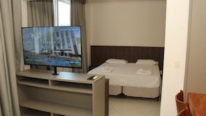 A hotel room with a television displaying a hotel website, a bed with two pillows, and a neatly made bed. - Barretos Park Hotel (Barretos)