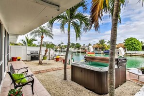 Een terras met een hottub, een zwembad en een barbecue.