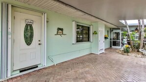 A building with a light green exterior, a white door with a green glass window, and a sign that reads "Laundry." - Canal View Summer Escape With Dock, Hot Tub and Cabana Club Access (Key Colony Beach, Marathon)