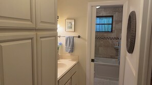 Une salle de bain avec une baignoire, un lavabo et des placards.