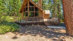 A cabin with a deck, large windows, and a chimney. - Rim Drive Lookout (Tahoe Vista)